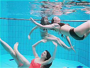 three nude ladies have fun underwater
